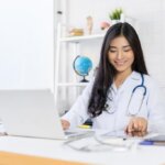 Woman doctor working on ECFMG updates for 2024