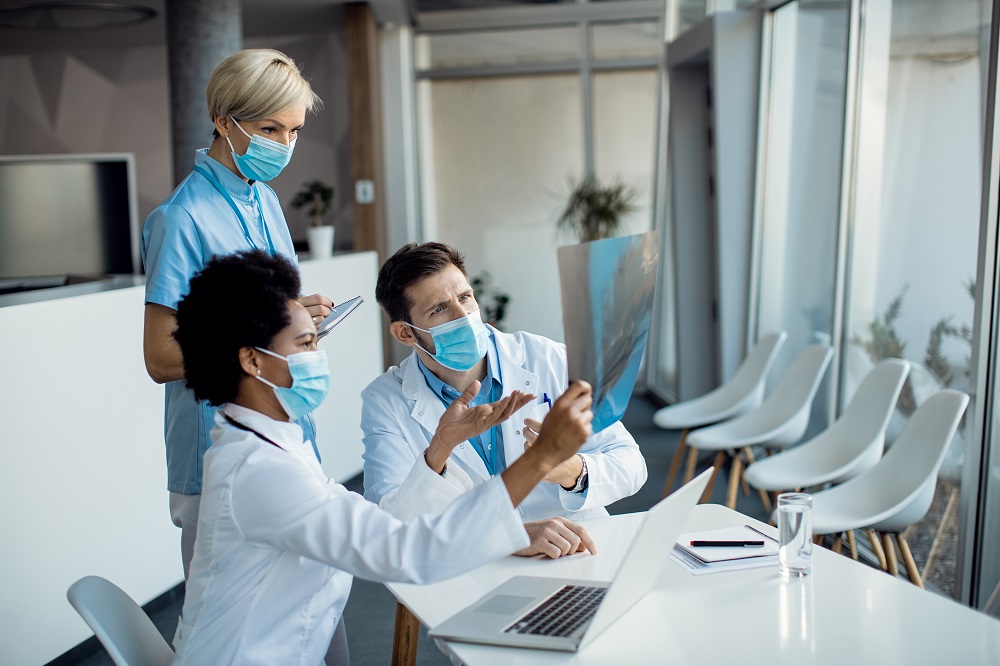 group doctors cooperating while examining xray patient hopital