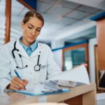 gmc licenced woman doctor reading patient documents in uk